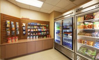 a well - stocked convenience store with various food items and drinks , including beverages in refrigerators at Sonesta ES Suites Phoenix Goodyear