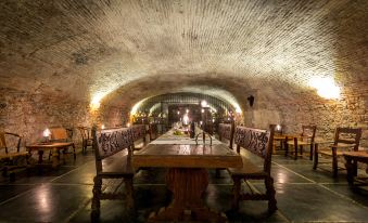 a long dining table with chairs is set up in a room with brick walls and a vaulted ceiling at Hacienda San Gabriel de las Palmas
