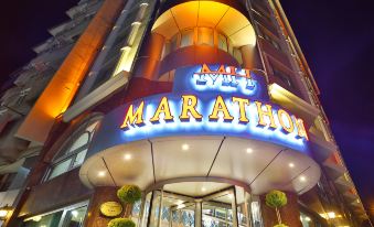 "a large building with a neon sign that says "" marathon "" on the front of the building" at New Marathon Hotel