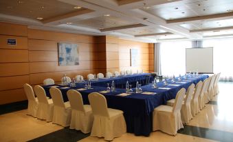 a conference room with blue tables and white chairs is set up for an event at Hotel Albufera