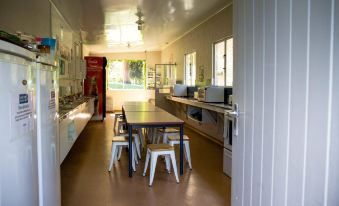a long , narrow room with a kitchen on the left side and a dining area on the right side at The Camp - Lake Hawea