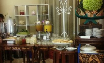 a dining area with a buffet table filled with various food items , including fruits , vegetables , and desserts at De View Hotel