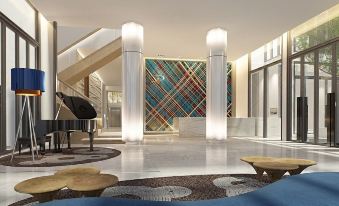 a grand foyer with a grand piano in the center , surrounded by a white marble staircase at Rattanachol Hotel