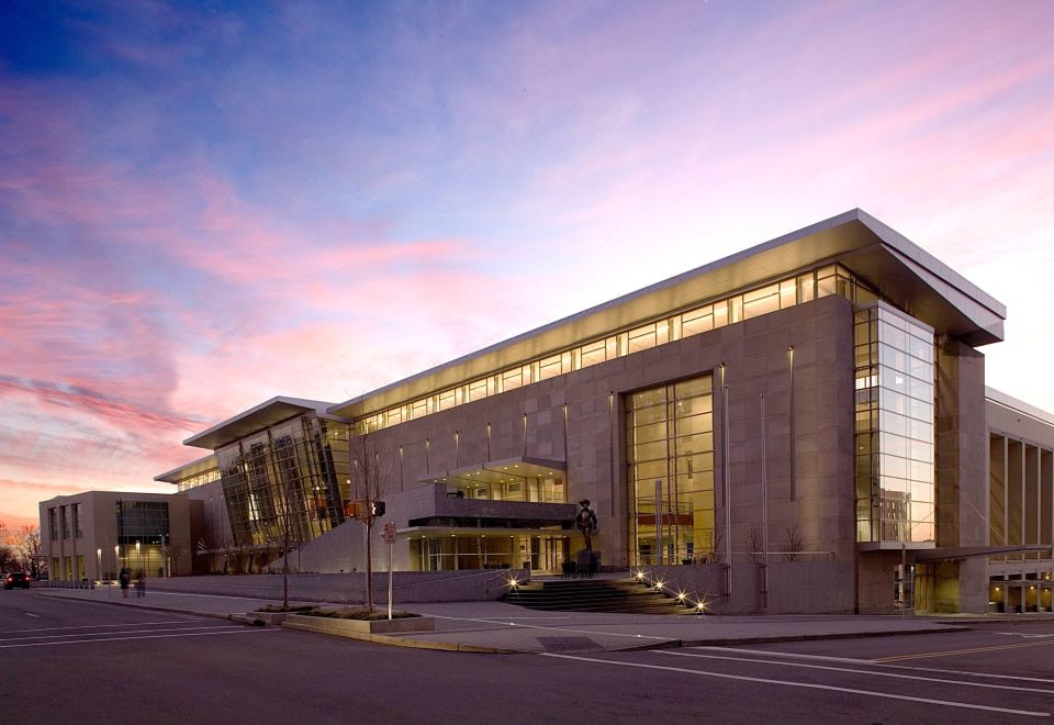 a large , modern building with a concrete facade and glass windows is shown at dusk at Raleigh Marriott City Center