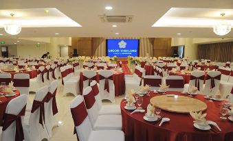 a large banquet hall filled with round tables and chairs , ready for a formal event at Saigon Vinh Long Hotel