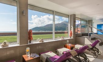 a room with two reclining chairs and a view of a mountain through large windows at Slieve Donard