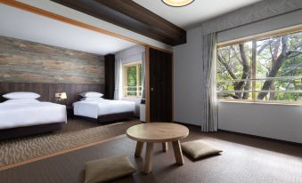 a modern hotel room with two beds , a round table , and a large window with curtains at Courtyard by Marriott Hakuba