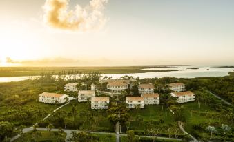 a bird 's eye view of a large property with multiple white houses surrounded by trees and water at Como Parrot Cay