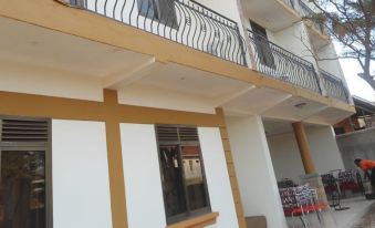 a two - story building with wooden beams and white walls , featuring a balcony with a railing at Coronation Hotel