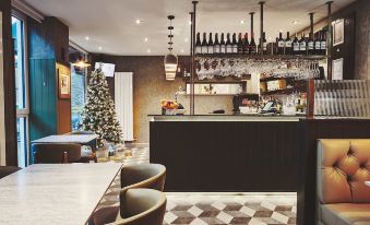 a well - decorated dining room with a christmas tree and a bar area filled with wine glasses at The Garrison