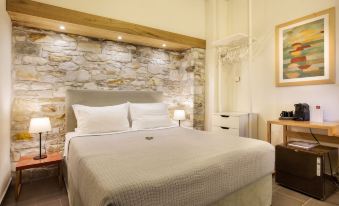 a large bed with a stone headboard is in a room with two nightstands and a wooden headboard at Olga