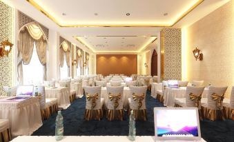 a large , well - lit conference room with rows of tables and chairs set up for a meeting or event at Alfahad Hotel