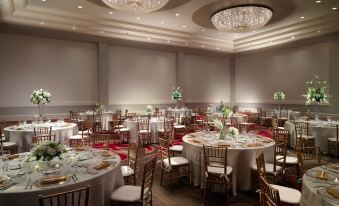 a large dining room with multiple tables and chairs , all set for a formal event at Omni Providence