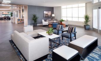 a modern living room with white and blue furniture , including couches , chairs , and a coffee table at Hyatt House Charleston/Mount Pleasant