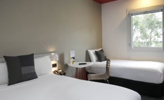 a hotel room with two beds , one on the left and one on the right side of the room at Ibis Sydney Airport