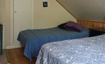 a room with two beds , one on the left and one on the right side of the room at Vadstena
