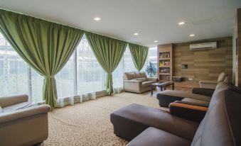 a spacious living room with multiple couches and chairs arranged around a coffee table , creating a cozy atmosphere at Hotel Sfera