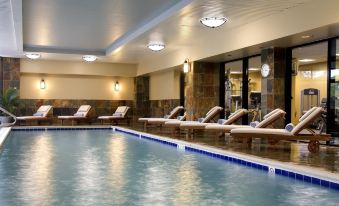 an indoor swimming pool with lounge chairs surrounding it , providing a relaxing atmosphere for guests at Hyatt Regency Dulles