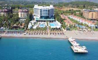 aerial view of a large hotel surrounded by a beach and ocean , with several boats in the water at Q Premium Resort