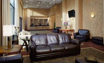 a well - appointed living room with a leather couch , several chairs , and a tv mounted on the wall at Paradise Stream Resort