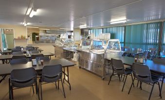 a cafeteria - style dining area with tables and chairs , as well as a buffet table filled with various food items at Discovery Parks – Biloela
