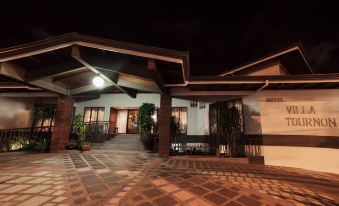 a modern building with wooden beams and tiled flooring , lit up at night , surrounded by greenery at Hotel Villa Tournon