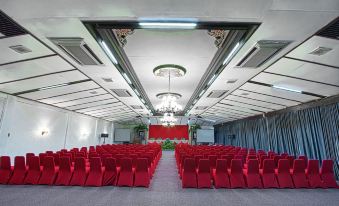 a large room with rows of red chairs arranged in an orderly fashion , possibly for a meeting or event at Kusuma Sahid Prince Hotel Solo