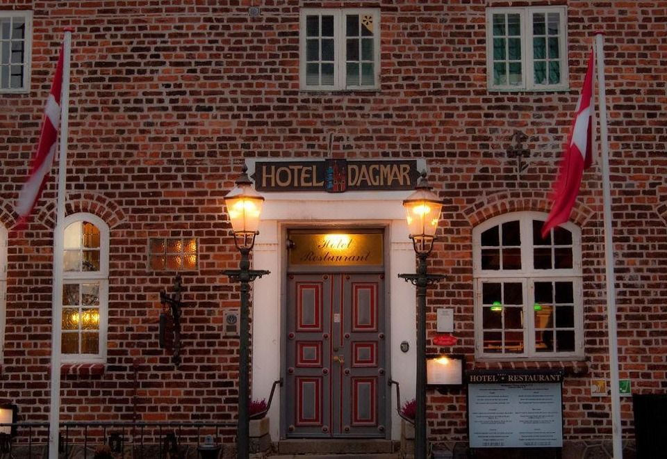 "a brick building with a sign above the door that reads "" hotel d ' agnais "" and two lanterns on either side" at Hotel Dagmar