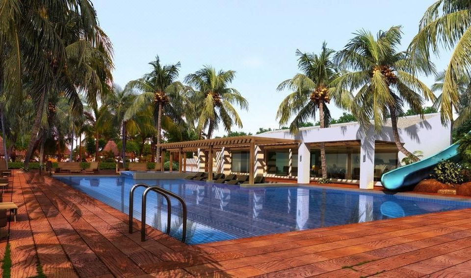 a large swimming pool surrounded by palm trees , with several people enjoying their time in the pool at Mount Sea Resort Hotel and Restaurant Cavite