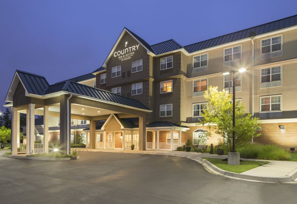 a large hotel building with multiple entrances , located in a residential area with trees and lights at Country Inn & Suites by Radisson, Baltimore North/White Marsh