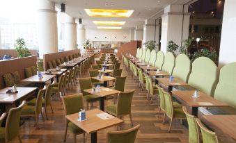 a large dining room with many tables and chairs arranged for a group of people at New Akan Hotel