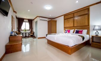 a large bedroom with a king - sized bed , hardwood floors , and a door leading to a balcony at Thatphanom View Hotel