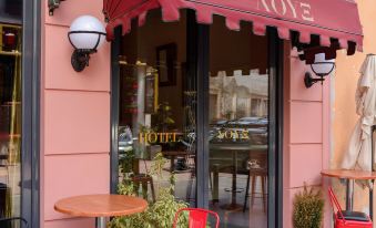 a restaurant with a red awning and outdoor seating area , inviting customers to enjoy their meal at Lux Hotel