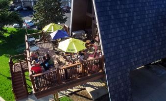 an aerial view of a group of people sitting at outdoor dining tables on a deck , enjoying food and drinks at Wrangler Inn Mobridge