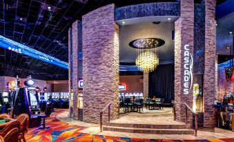 a large , ornate room with a staircase leading to the second floor and a chandelier hanging from the ceiling at Akwesasne Mohawk Casino Resort and Players Inn Hotel -Formerly Comfort Inn and Suites Hogansburg NY