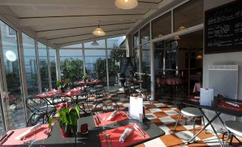 an outdoor dining area with tables and chairs arranged for a group of people to enjoy a meal together at Ibis Nantes Saint-Herblain