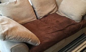 a white couch with brown and beige pillows is sitting in a living room next to a kitchen at Town Apartments