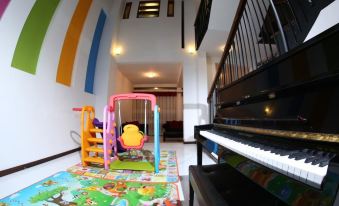 a playroom with a variety of toys , including a rocking horse , a piano , and a swing at Capital Villa