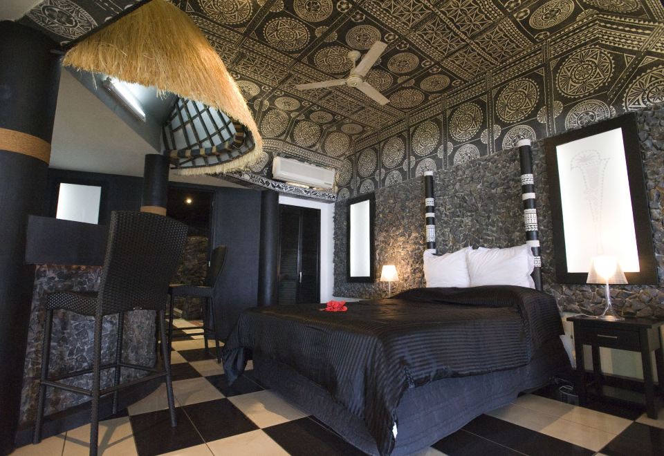 a black and white bedroom with a large bed , a ceiling fan , and a rug on the floor at Stevensons at Manase