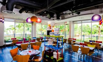 a brightly lit restaurant with various dining tables and chairs , creating a vibrant atmosphere for guests at Legoland® Florida Resort