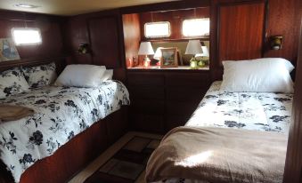 a small room with two twin beds , one on each side of the room , and a bedside table at Cookie B