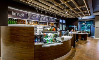 a modern coffee shop with a curved wooden counter and various food items displayed on the counter at Courtyard Columbia Cayce