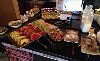a buffet table filled with various types of food , including fruits , nuts , and other dishes at Hotel Brunnenhof