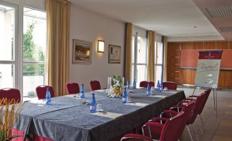a conference room set up for a meeting , with tables and chairs arranged in a semicircle at Hotel Caesius Thermae & Spa Resort
