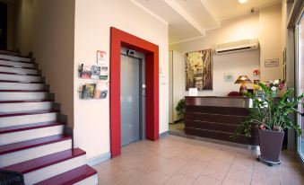 a modern interior with red doors , white walls , and wooden floors , as well as an office area with a desk and a staircase at Easy Space