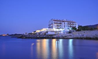 a large building with multiple floors , situated on the shore of a body of water at Manolya Hotel