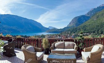 a balcony overlooking a body of water , with several chairs and couches placed on the balcony for relaxation at Hotel Olympia