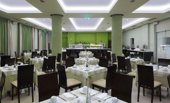 a large dining room with tables and chairs arranged for a group of people to enjoy a meal together at Arion Hotel