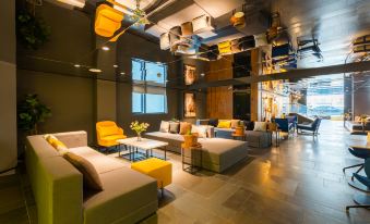 The lobby features couches and tables in the center, creating an open concept living space at CitiGO Hotel, West Nanjing Road, Jing'an Temple, Shanghai