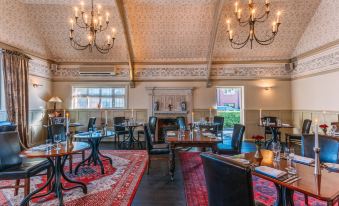 a large , elegant dining room with multiple tables and chairs arranged for a group of people at Colwall Park - Hotel, Bar & Restaurant